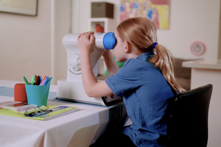 A child looking through a device
Description automatically generated